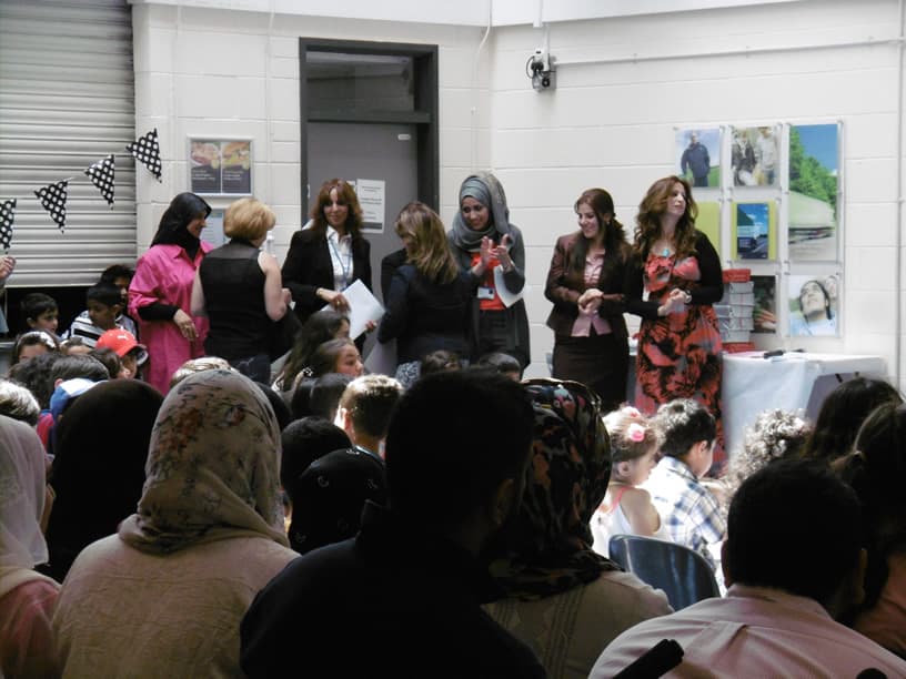 Babylon Academy staff addressing parents and pupils gathered in the school hall.